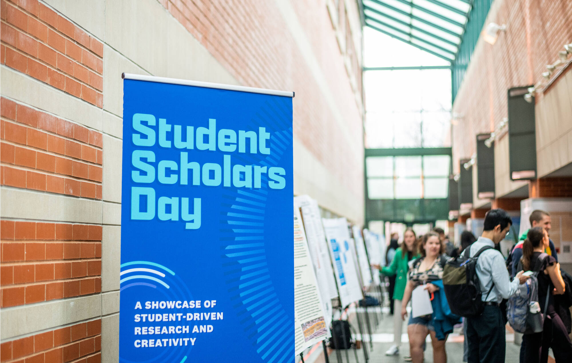 Students and faculty attending poster presentations at Student Scholars Day.